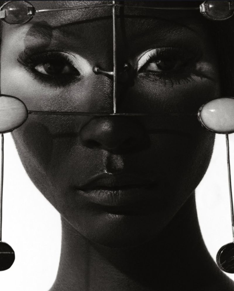 Striking black-and-white portrait of a woman with distinctive headpiece. Sharp focus on facial details and contrasting tones create a dramatic effect.