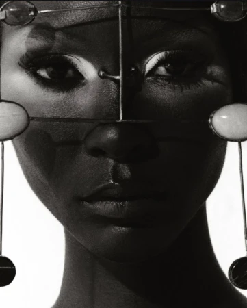 Striking black-and-white portrait of a woman with distinctive headpiece. Sharp focus on facial details and contrasting tones create a dramatic effect.