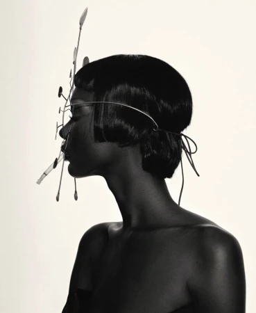 Profile portrait of Mahany Pery wearing a wire headpiece with a cigarette for Elle Brasil photographed by Mar plus Vin.
