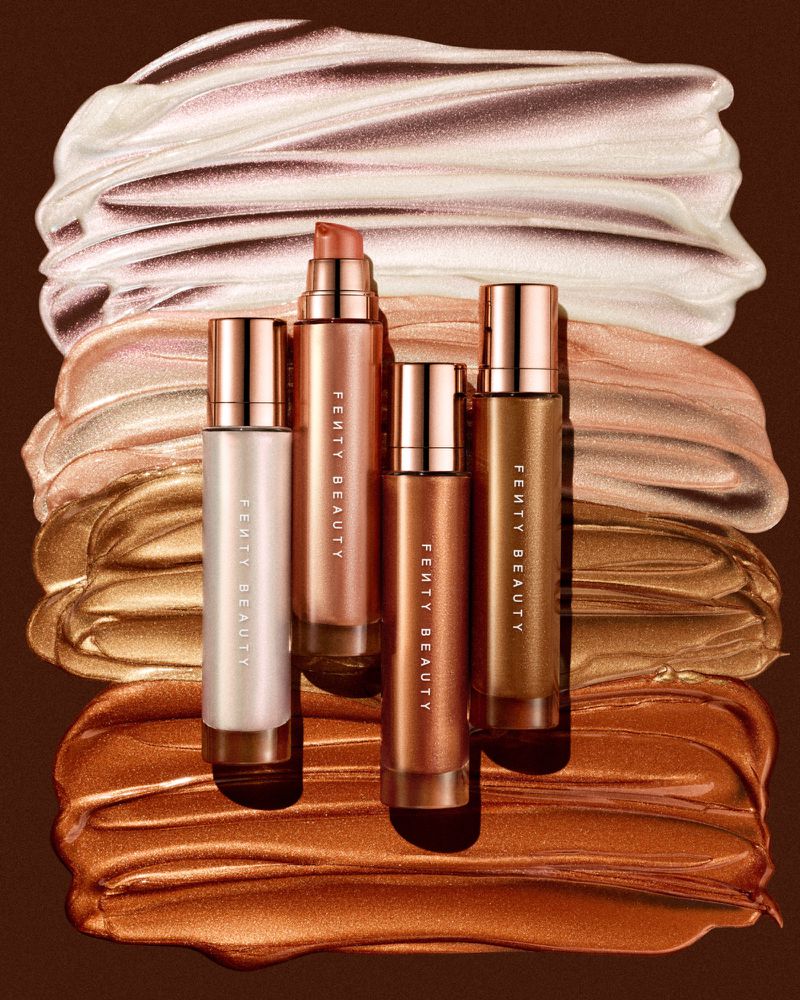 Fenty Beauty products arranged against shimmering cosmetic smears in bronze, gold, and white tones with sleek metallic packaging.