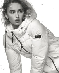 Model in a white puffer jacket posing against a plain background in a black and white fashion portrait.