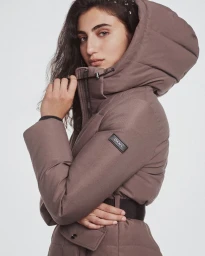 Model wearing a taupe hooded puffer jacket with a black belt against a neutral background