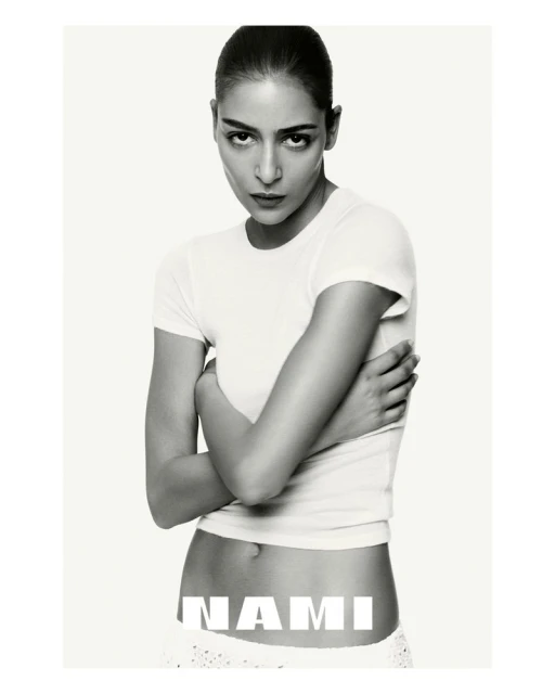 Monochrome portrait of a female model in a white t-shirt with crossed arms and neutral expression, against a plain white backdrop with text.