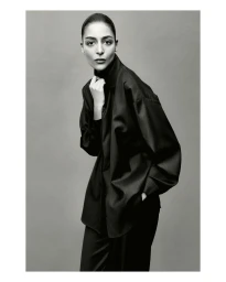 Model Nora Attal wearing a dark collared shirt against a grey seamless background for Nami Drop 4