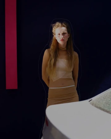 Blonde woman in neutral-toned outfit poses next to a modern white car against a dark backdrop with a vertical pink stripe.