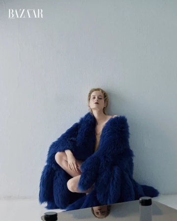 Model Sterre Haket in a royal blue fluffy coat against a plain pale wall for Harper's Bazaar Mexico, photographed by Alfonso Anton Cornelis.
