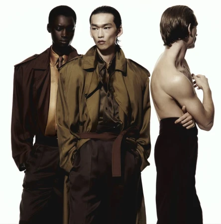 Three male models posing against a bright white background wearing tailored coats and trousers