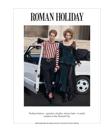 Editorial fashion shot of a male and female model in designer clothing posed by a white car against a classical building backdrop.
