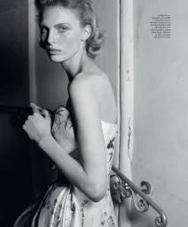 Black and white portrait of a model in a patterned dress standing on a staircase for WSJ project Roman Holiday