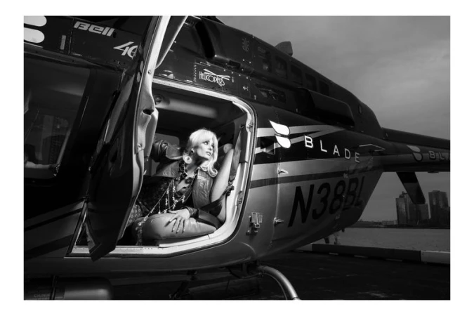Model Taylor Hill seated inside a helicopter cabin wearing layered jewelry for Woman Magazine editorial photography.