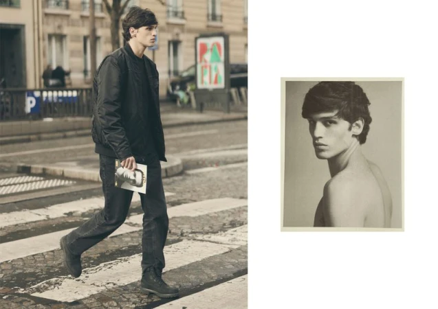 Fashion shot of a young man walking across a crosswalk in a city, wearing all black, and holding a magazine with a portrait image inset.