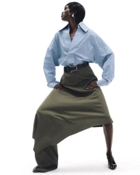 Model Amar Akway in blue striped shirt and olive skirt on white background for Document Journal
