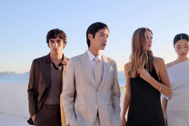 Four models in formal attire outdoors by the water for the BOSS SS26 campaign