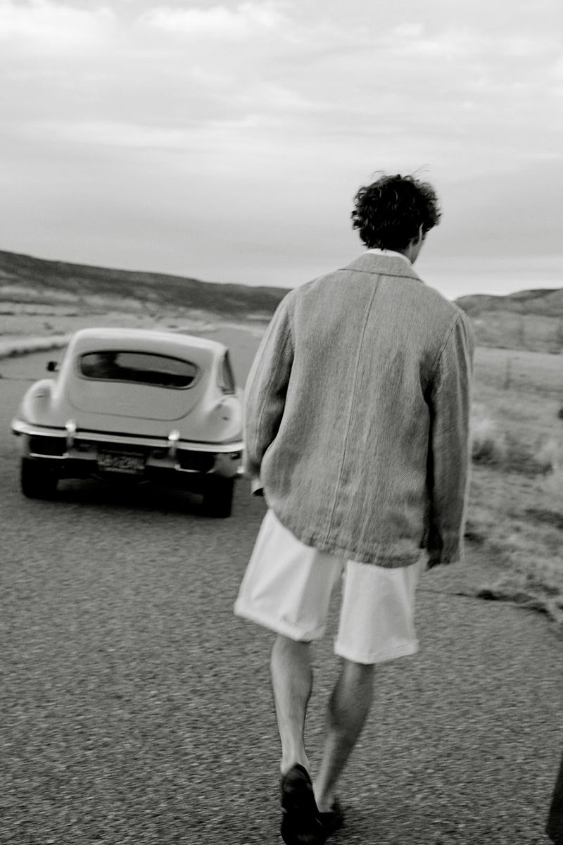 A man walking away on a desert road near a vintage car for Banana Republic