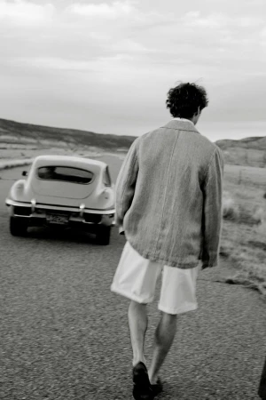 A man walking away on a desert road near a vintage car for Banana Republic