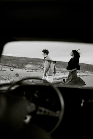 Black and white shot of a man and woman running past a car viewed through a car windshield, captured for Banana Republic.