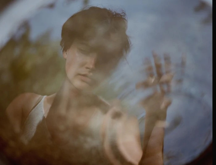 Model reflected in water with a raised hand for Polene Paris Longue Vue Edition photographed by Sebastian Sabal-Bruce