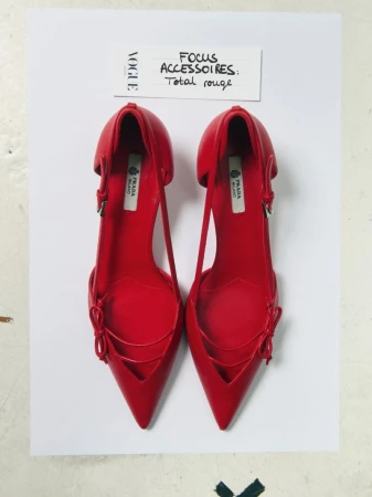 Pair of red Prada slingback shoes on white backdrop, arranged with 'Vogue' magazine swatch and 'Focus Accessoires: Total rouge' text.
