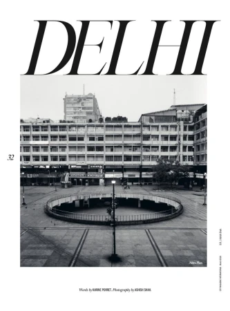 Monochrome shot of a civic plaza in Delhi, India, showcasing a circular sunken area and surrounding buildings under an overcast sky.