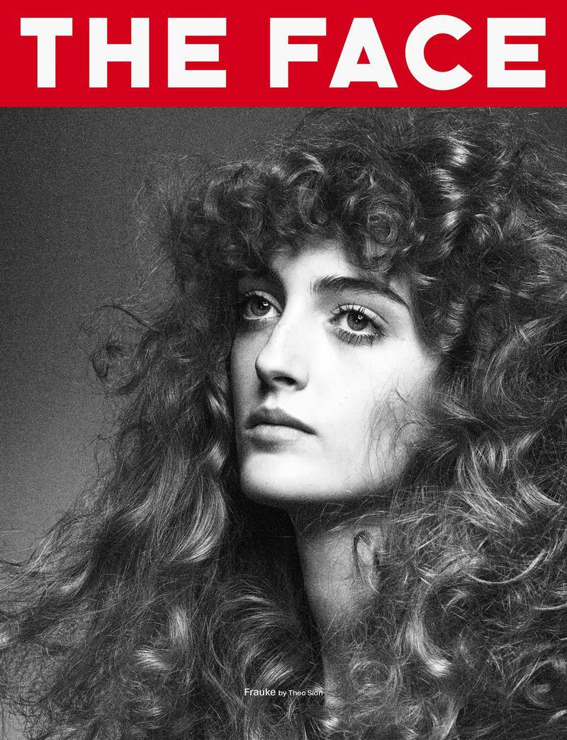 Black and white magazine cover featuring a woman with curly hair looking upwards, with the magazine's title in bold red text.