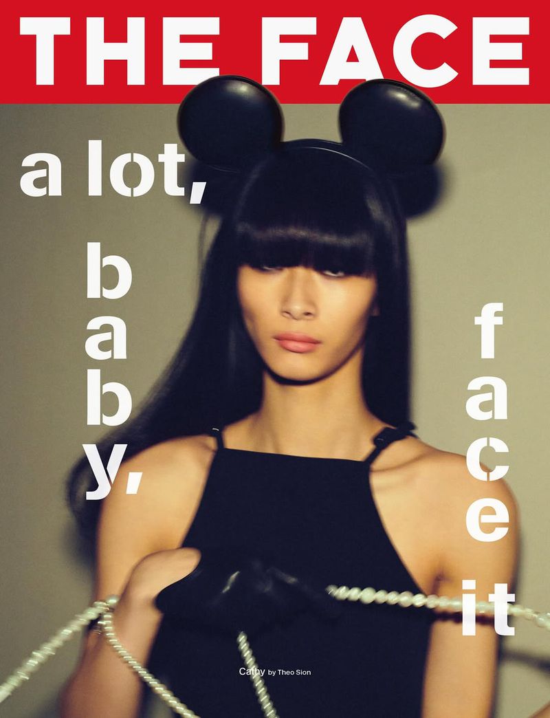 Magazine cover featuring a model with black bangs and Mickey Mouse ears, wearing a black dress and pearls against a neutral backdrop.