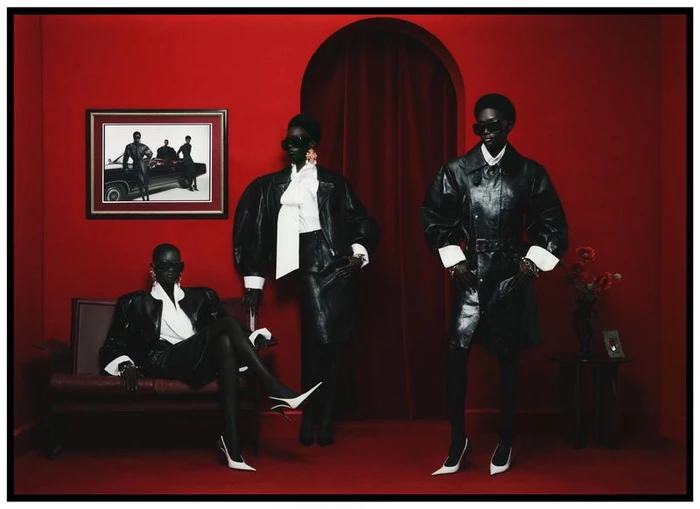 Three models wearing black leather coats and sunglasses in a monochromatic red interior for Numero France by Kenny Germé