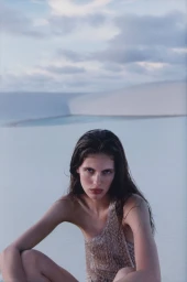 Model Rosalieke Fuchs in a textured top seated against a sandy dune landscape for Harper's Bazaar U.S.