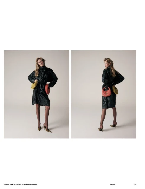 Fashion editorial shot of a blonde woman wearing a black dress with colorful round purses, posing in a photo studio with a neutral backdrop.