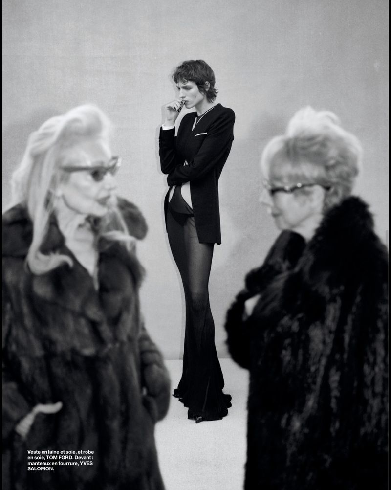 Fashion editorial shot featuring a central model in a jacket and sheer pants, flanked by two older women in fur coats and sunglasses.