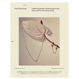Delicate gold jewellery and a diamond pendant necklace displayed on a white anthurium leaf and stem against a light background