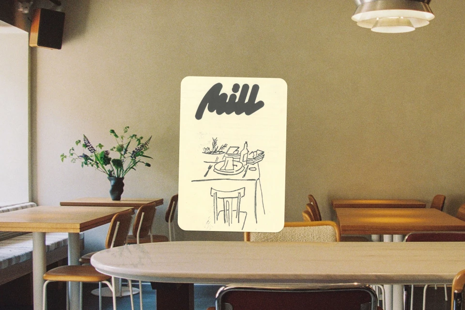 Illustration of a dining table setting on a menu card in a cafe, with wooden chairs and tables visible in the background.