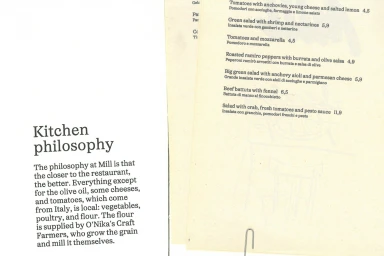 Printed restaurant menu and philosophy text on cream paper with black typography for Mill brand identity