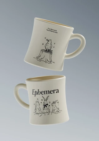 Two white ceramic coffee mugs with illustrated designs of an owl and rabbits float on a gray background in a product shot.