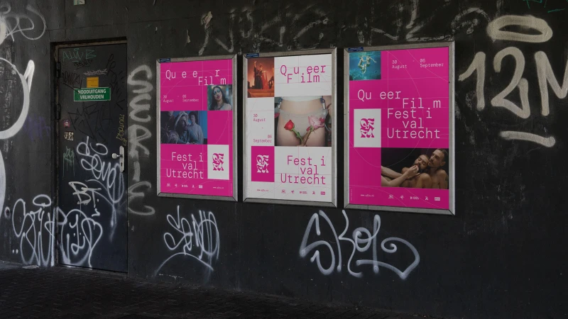 Three Queer Film Festival posters on a graffiti-covered wall show diverse images and dates, promoting the event in Utrecht.