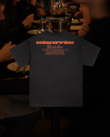 A black t-shirt featuring an orange Nikotin Restobar logo is displayed with people at a dining table in the background.