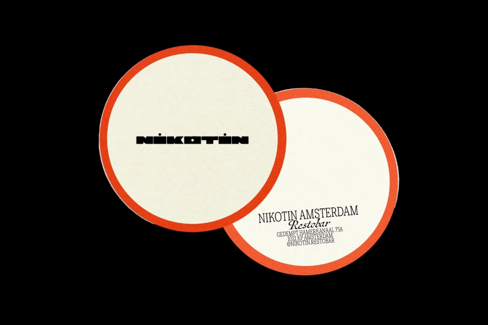 Two cream-colored round coasters with a red border feature the brand name "Nikotin Amsterdam Restobar" in black text on a dark background.