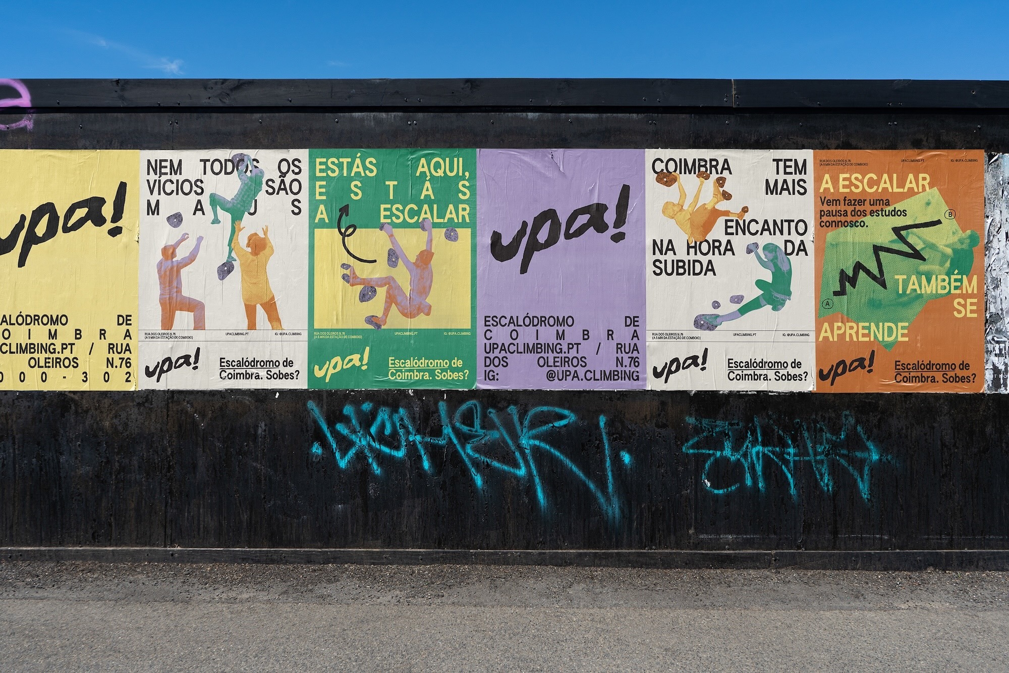 Colorful posters on a wall in Coimbra, Portugal promoting UPA Climbing, an indoor climbing gym with a modern, artistic style and graffiti.