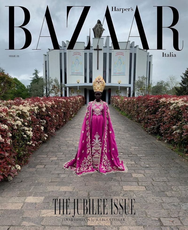 Harper's Bazaar Italia cover features a Black woman in a pink and gold dress and headdress, standing on a stone path with a church in the background.