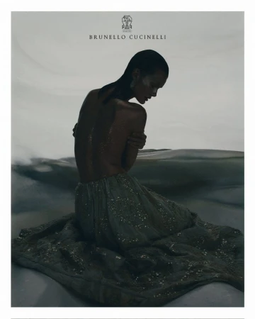 Woman with wet hair sits in a sparkly dress on light reflecting surface, back to camera, pale background, and Brunello Cucinelli logo.