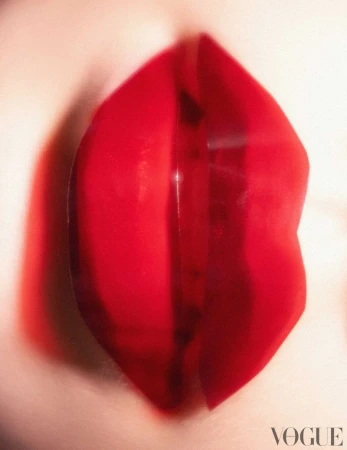 Close-up macro shot of glossy bright red lips with visible texture and soft lighting for Vogue Portugal editorial