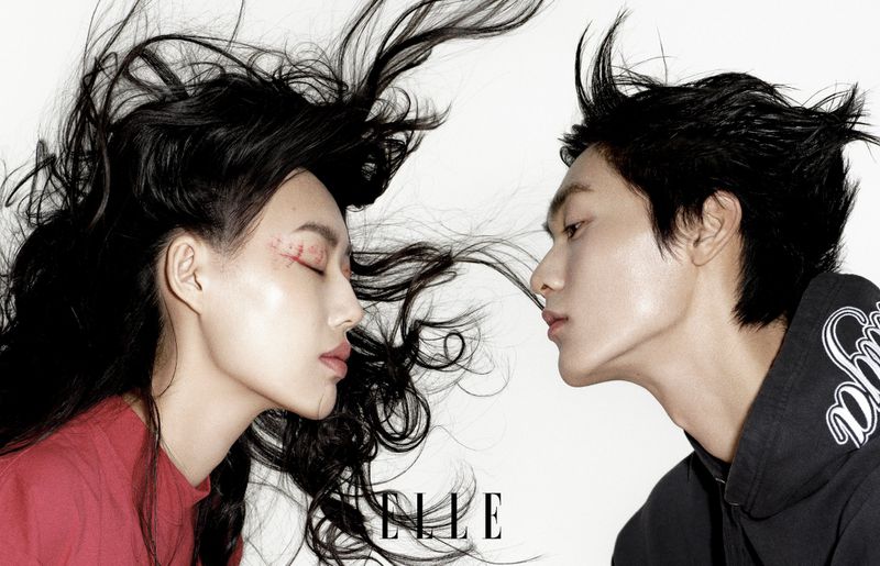 Close-up of a stylish couple with black hair in profile against a white background, showcasing a modern and intimate aesthetic.