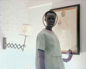 Model Aker Ajak posing indoors in a mint green dress and purple gloves for a Purple Magazine editorial photographed by Torbjørn Rødland.