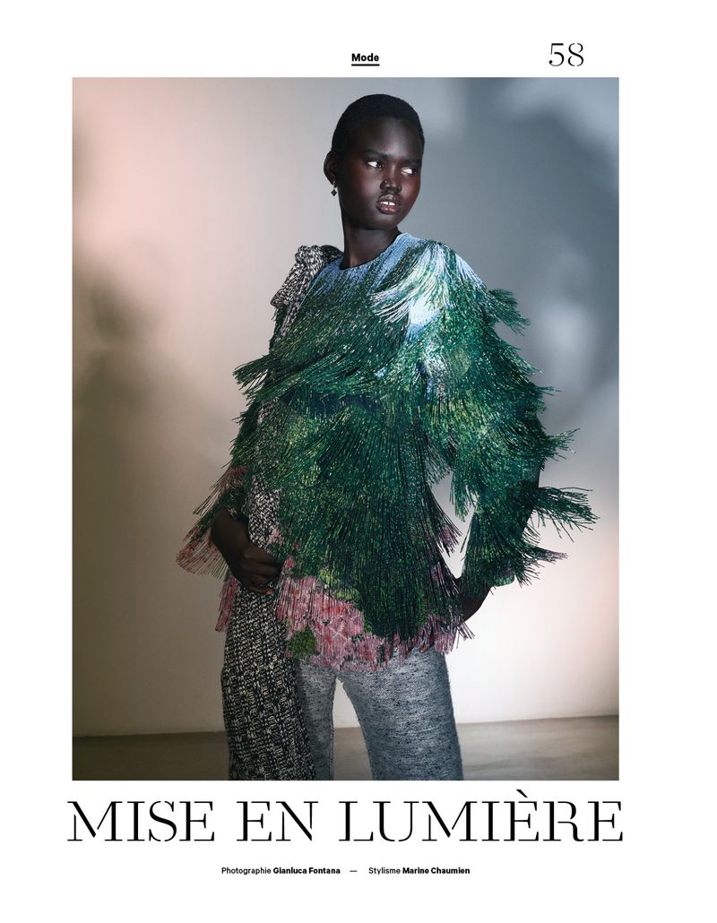 Model wearing a textured green fringed top and grey trousers against a studio backdrop for Les Echos