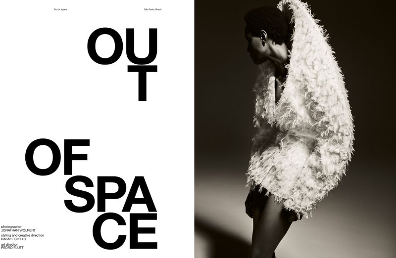 Fashion editorial shot of a Black woman in a feather-like coat against a gradient background, with bold 'OUT OF SPACE' text.