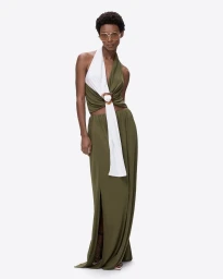 Model wearing tinted oversized aviator sunglasses and a two-tone halter top with a long olive green maxi skirt on a white background