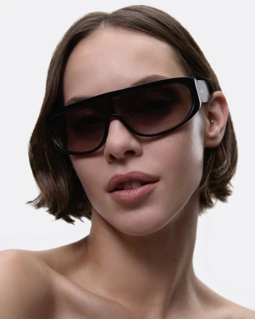 Model wearing dark oversized sunglasses against a white background for Deering eyewear