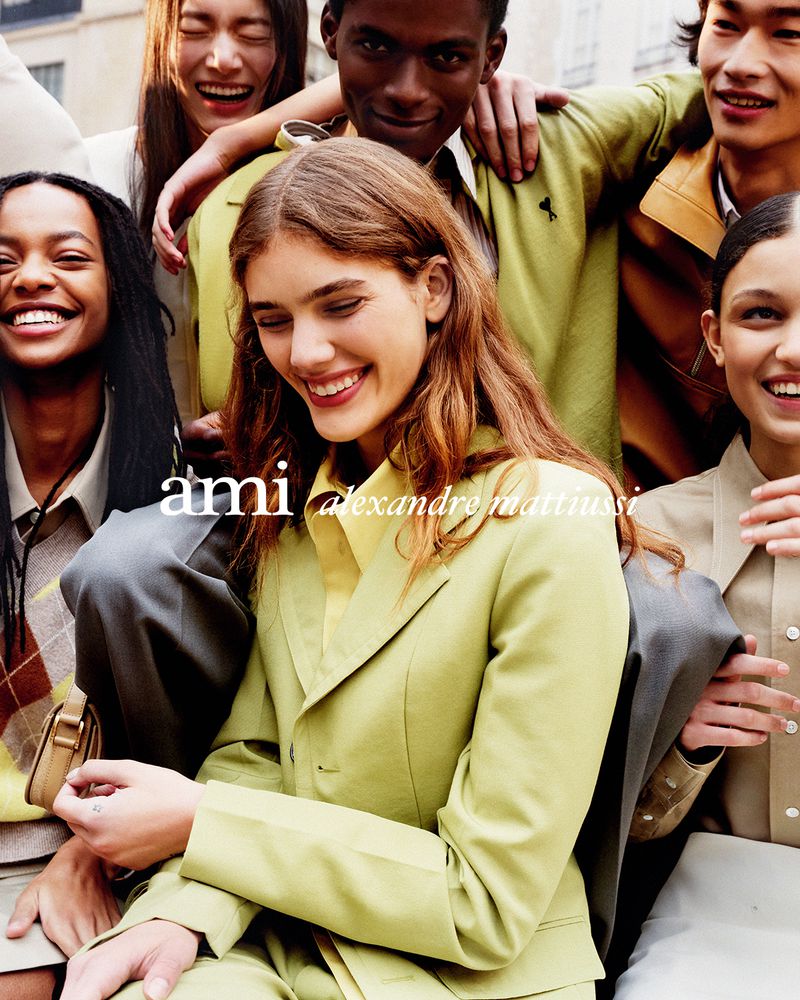 Group of smiling young adults wearing fashionable colourful clothing outdoors, posing for an outdoor portrait, fashion photography.
