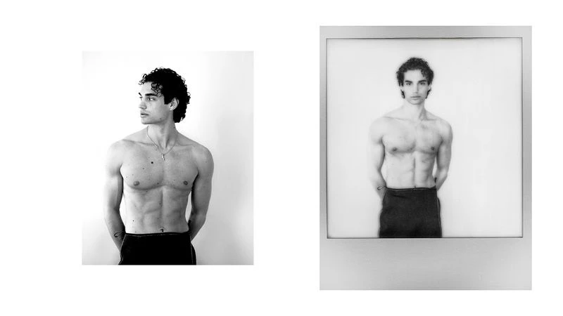 Black and white studio portrait of a shirtless adult male with curly hair, standing indoors, with a matching framed image to the right.