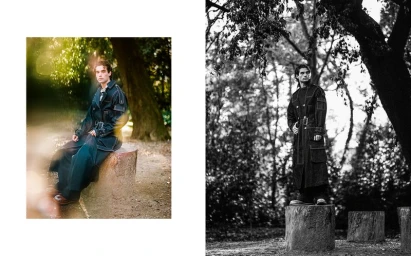 Man wearing a long dark coat standing and sitting on tree stumps in a park for Positive Magazine editorial