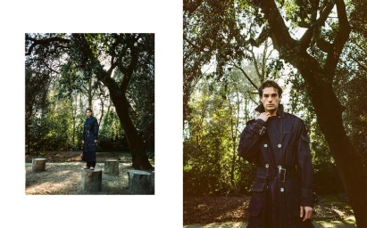 Diptyque fashion editorial featuring a man in a dark denim coat posing outdoors among trees for Positive Magazine.